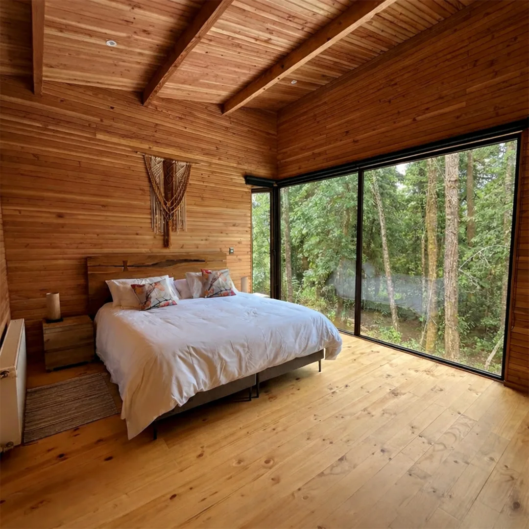 Dormitorio principal con ventanal al bosque